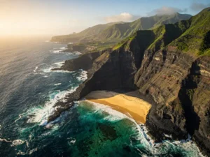 Luchtfoto van een vulkanische kustlijn op Kaapverdië met zwarte lavakliffen, turquoise Atlantische golven en een gouden zandstrand in een beschutte baai.