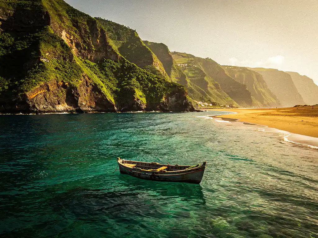 Verweerde vissersboot voor kliffen van Madeira en gouden stranden van Kaapverdië, verbonden door turquoise Atlantisch water.