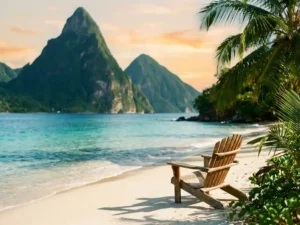 Wit zandstrand op Saint Lucia met turquoise Caribisch water, weelderige palmen en vulkanische bergtoppen in gouden avondlicht.