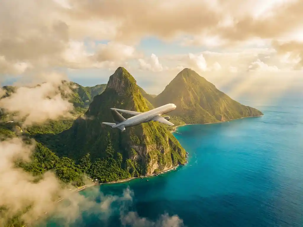 Vliegtuig boven de turquoise Caribische zee bij Saint Lucia's Piton-toppen, omgeven door weelderig groen regenwoud en gouden zonlicht.
