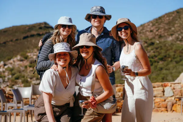 Vijf collega's poseren voor een groepsfoto tijdens een safari op bedrijfsreis naar Zuid-Afrika