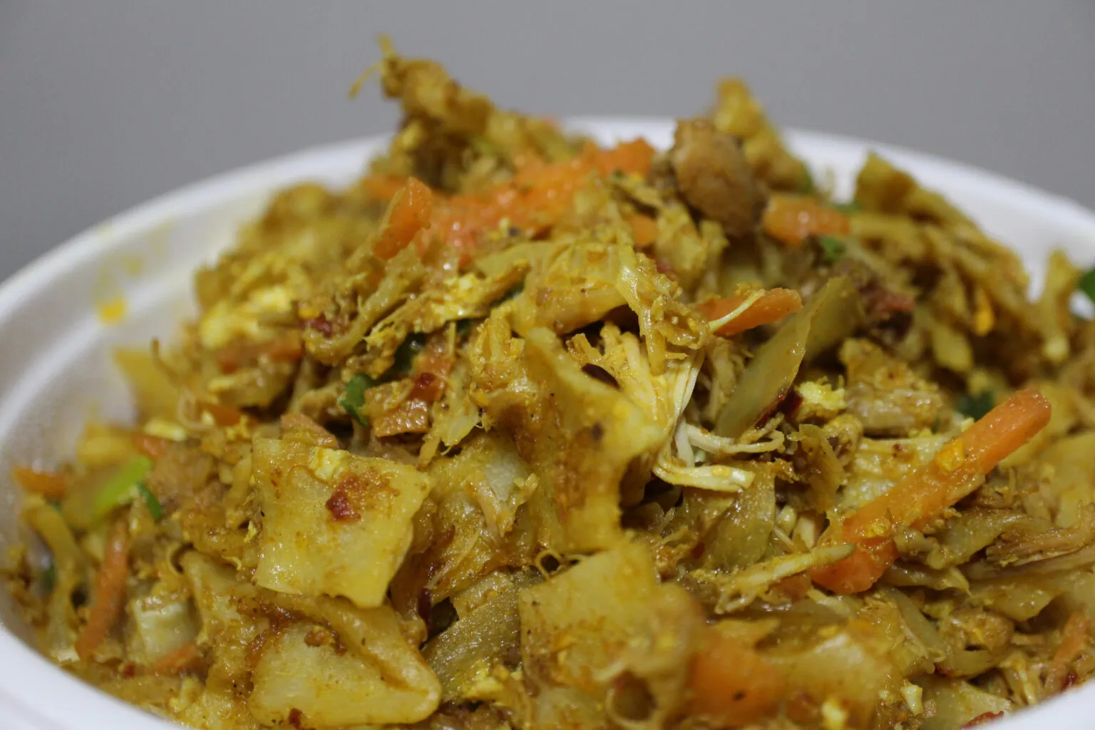 Een kom gevuld met kottu roti, een traditioneel Sri Lankaans gerecht van fijngesneden roti-brood gemengd met groenten en kruiden.